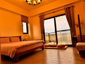 una camera da letto con un letto e una grande finestra di 舊事民宿 Old things in quemoy a Hu-hsia