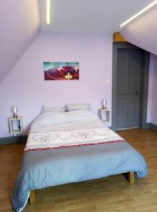 a bedroom with a bed with a painting on the wall at Nouveau loft à moins de 100m du lac classé 2 étoiles in Gérardmer