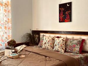Un dormitorio con una cama con almohadas encima. en La Casa by Cosmic Kriya, en Bīr