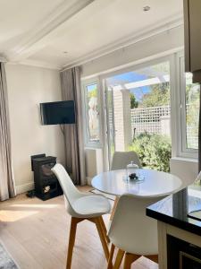 un soggiorno con tavolo e sedie bianchi di Garden Cottage - Leafy Constantia Guest House a Città del Capo