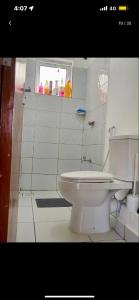 um banheiro branco com um vaso sanitário e uma janela em Giana’s stays with pool em Mombaça