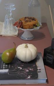a book with a pumpkin and a cake on a table at Casa Fellin 1891 B&B in Cles