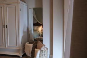 a room with a bedroom with a mirror and a chair at Casa Fellin 1891 B&B in Cles