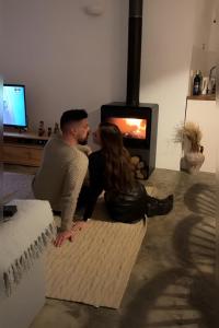 a man and a woman sitting in front of a fireplace at Casa Alquerque in Monsaraz