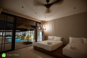 a bedroom with a bed and a view of a pool at Ipoh Tiga Pool Villa by Papahost in Ipoh +54 photos