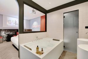 a bathroom with a tub with two bottles of wine at Magnifique Studio 2P avec Jacuzzi et Cinema in Paris