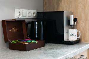 a kitchen counter with a coffee maker and a microwave at Sovanova Domki w Górach Sowich z Tarasem i Widokiem in Kolce