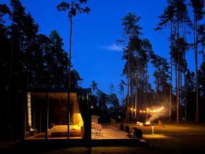 a bedroom in a tree house at night at Mustika Mirror minivilla saunaga in Kärdla