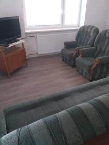 a living room with two chairs and a tv at rodinný dům in Třebíč +2 photos