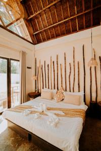a bedroom with a large bed with a wooden headboard at NYLA Boutique Resort Siargao in General Luna +58 photos