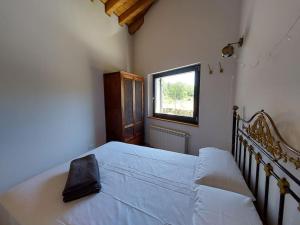 a bedroom with a large white bed with a window at Casa rural La Casaca en plena sierra de Gredos in Los Narros