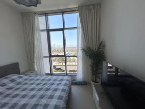 迪拜Shared Apartment In Dubai Hills的卧室配有一张床,窗户前种植了植物