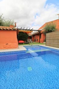 a large blue swimming pool in a yard at Casa de la Jara by SIERRA VIVA in La Nava