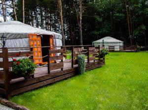 a yurt with a fence and a grass field at Ostoja Czarownic in Nida
