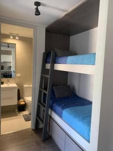 a bedroom with two bunk beds and a bathroom at Costa Montemar Concón, acogedor depatamento in Concón +23 photos