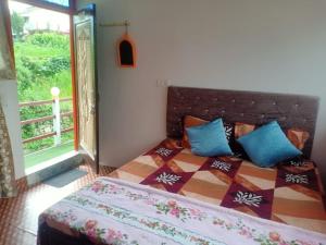 a bedroom with a bed and a window at Odyssey Stays Khirsu in Pauri