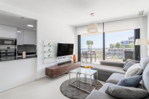ein Wohnzimmer mit Sofa und Tisch in der Unterkunft Infinity View luxury beachfront apartment in Arenales del Sol