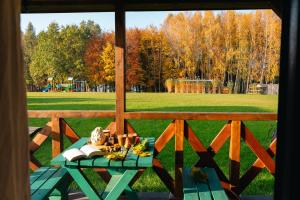 a table on a porch with a view of a field at Przystań Jeziorany - domki na mazurach in Jeziorany