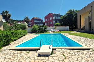 a swimming pool in the backyard of a house at Apartment Oliva Rab in Kampor