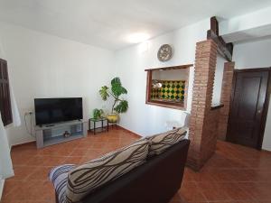 a living room with a couch and a television at Red House in Alhaurín el Grande