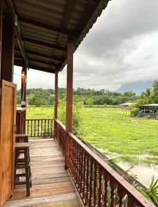 a porch of a house with a view of a field at Lomjoy House in Chiang Dao