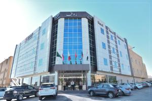 リヤドにあるRoof Hotel Apartmentsの駐車場に車が駐車されている大きな建物