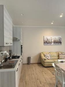 una cucina e un soggiorno con divano di Casa Erminia a Caserta