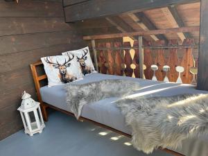 a bed in a log cabin with two deer pillows at Casa Tresch Sedrun Tujetsch bis 5 Pers in Sedrun