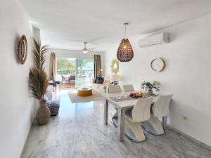 a dining room and living room with a table and chairs at House of Sun Calahonda in Sitio de Calahonda