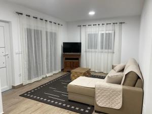 a living room with a couch and a television at Alojamentos da Aldeia in Vila de Rei