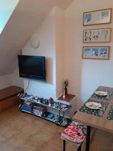 a living room with a tv and a table at Alojamiento esqui montaña Cofiñal in Cofiñal +22 photos