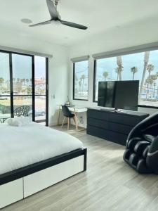 een slaapkamer met een bed en een flatscreen-tv bij Beach House with Rooftop Jacuzzi in Huntington Beach