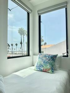 een bed met een kussen voor een raam bij Beach House with Rooftop Jacuzzi in Huntington Beach +61 foto's