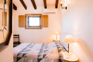 una piccola camera da letto con un letto e una finestra di Vilas da Matagosa a Matagosinha
