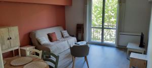 ニヨンにあるAppartement au cœur de Nyonsの小さなリビングルーム(ソファ、テレビ付)