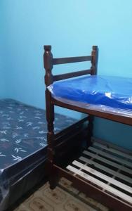 un lit en bois avec des draps bleus dessus dans l'établissement Casa Praia Mongagua - Cantinho Familia pé na Areia, à Mongaguá