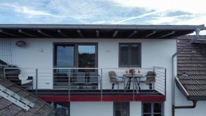 een balkon van een huis met een tafel en stoelen bij Ferienwohnung Mariposa in Böbing