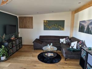 een woonkamer met een bank en een tafel bij Ferienwohnung Mariposa in Böbing