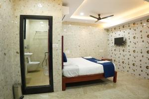 a bedroom with a bed and a bathroom with a shower at Akshayaa Grand in Visakhapatnam +24 photos