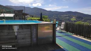 a hot tub on a deck next to a swimming pool at Chalet avec vue sur la vallée in Saint-Maurice-sur-Moselle