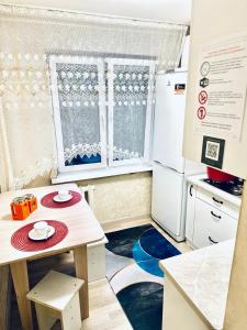 a small kitchen with a table and a refrigerator at микрорайон 9 in Almaty