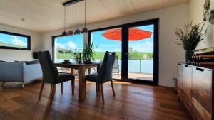 a dining room with a table and chairs with a view at Gästehaus Casa Luna - Paradiesische Ferienwohnungen am Kaiserstuhl! in Bischoffingen