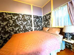 a bedroom with a bed and a floral wall at Shinjuku, 3min walk from Nishi-Shinjuku 5-chome Sta, 3min Shinjuku Sta Switch, Wi-Fi ,Pocketwi-Fi in Tokyo