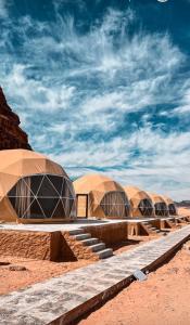 a row of domed tents in the desert at Tamim Luxury wadi rum camp in Wadi Rum