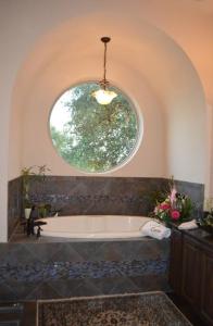 a bathroom with a tub with a round window at Villa at Cibolo Chase, a private resort with pool in Bulverde