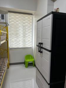 a bedroom with a door and a green stool at Solana Tower 1 New and Very Neat Studio Unit near SM Manila in Manila