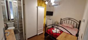 ein kleines Schlafzimmer mit einem Bett und einer roten Decke in der Unterkunft Hotel Mondial 2 in Villasor