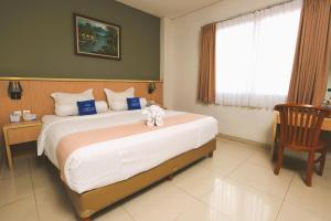 Ένα ή περισσότερα κρεβάτια σε δωμάτιο στο Hotel Dafam Rio