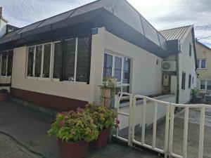 a house with two potted plants in front of it at Apartman Mole in Livno +4 photos