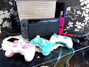 a table with two video game controllers and a monitor at Shinjuku, 3min walk from Nishi-Shinjuku 5-chome Sta, 3min Shinjuku Sta Switch, Wi-Fi ,Pocketwi-Fi in Tokyo